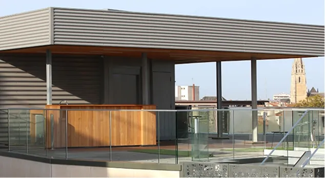 Moderne architecture contemporaine avec structure en bois et verre près d’un clocher historique