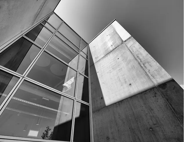 Architecture moderne avec structure béton et façade vitrée géométrique
