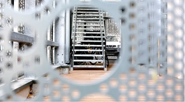 Escalier métallique industriel vu à travers une grille transparente