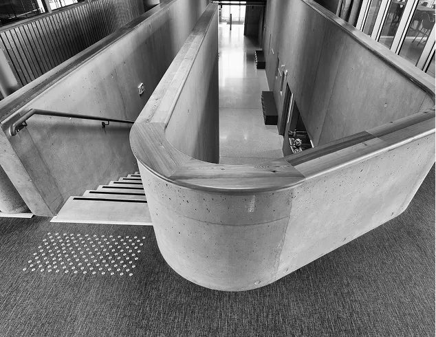 Escalier moderne en béton architectural avec garde-corps métallique et sol texturé